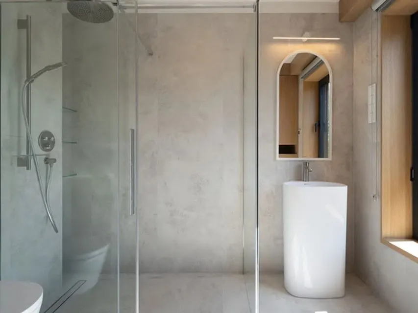 Badezimmer mit bodengleicher Dusche, freistehender Wanne und großformatigen Fliesen
