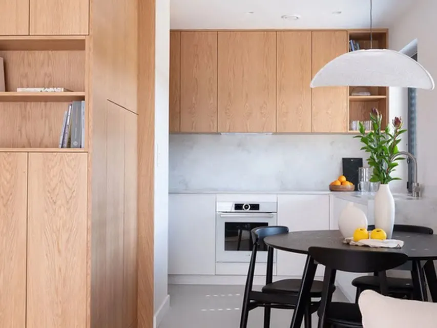 Einbauküche mit Holzfronten, Arbeitsplatte und Essbereich