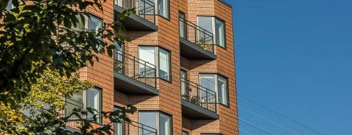 Mehrgeschossiges Wohngebäude mit Klinkerfassade und auskragenden Balkonen