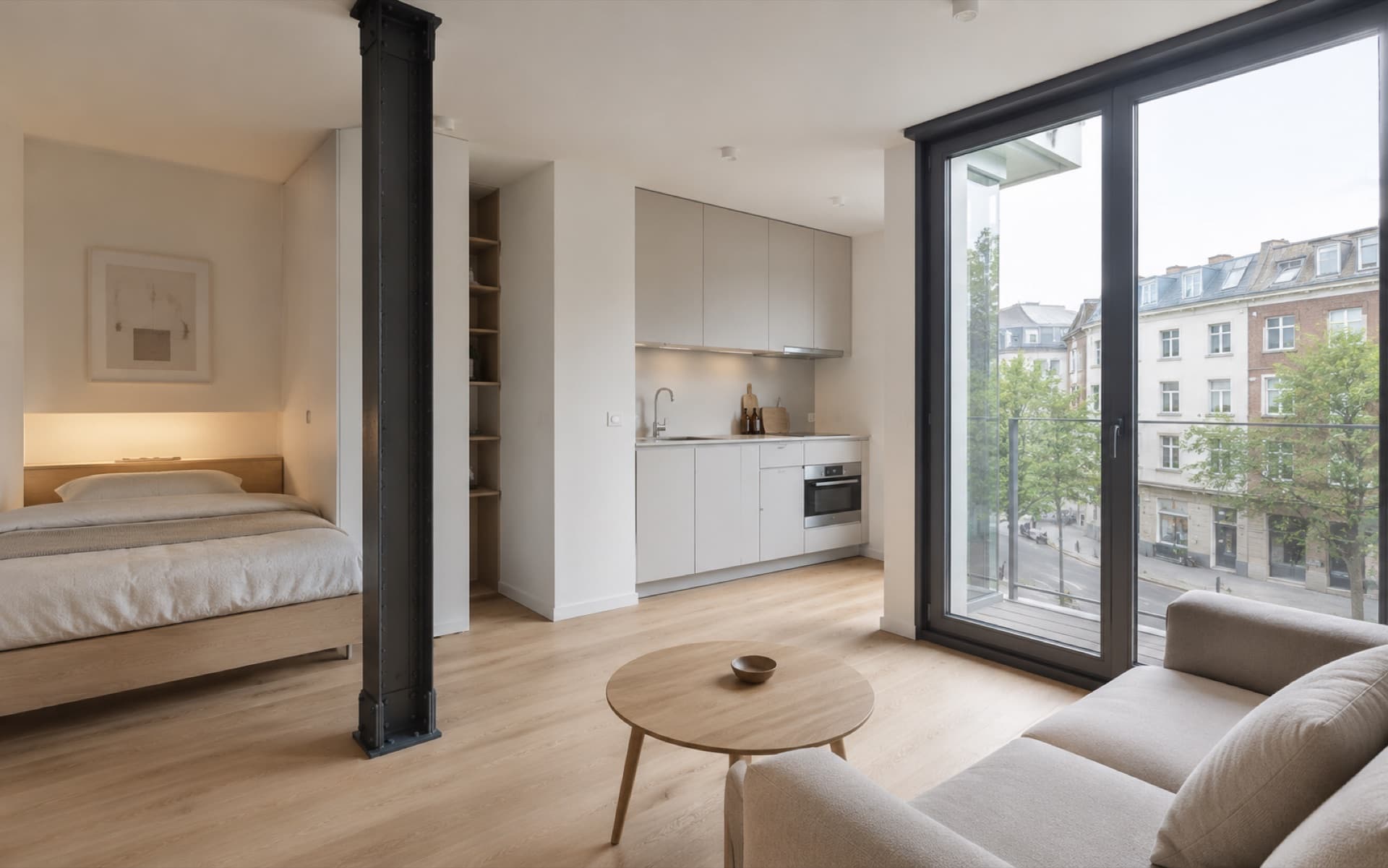 Mikro-Living-Einheit von innen: Schlafnische, kompakte Küchenzeile und bodentiefes Fenster mit Blick auf die Stadt — Visualisierung